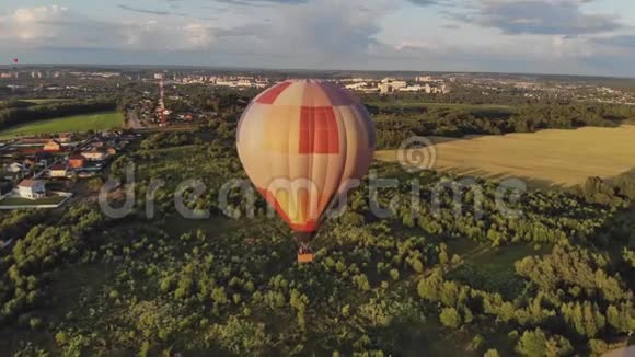 大热气球飞在小镇附近的绿色森林里视频的预览图