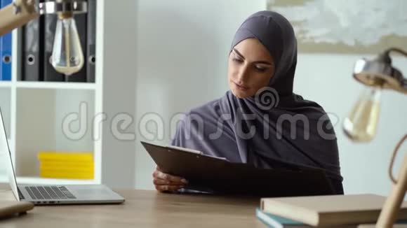 从事文件工作的穆斯林妇女视频的预览图