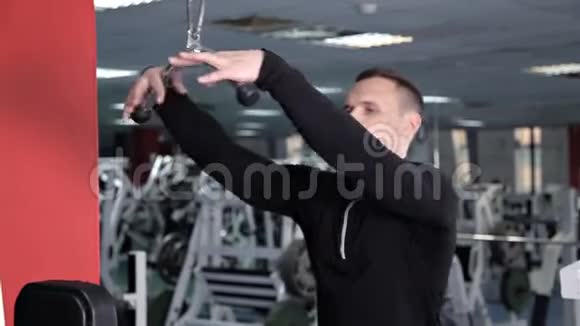 在模拟机上锻炼手臂和肩膀肌肉的运动青年视频的预览图