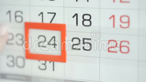 女人在墙上的日历上交办公室更改日期变动24至25视频的预览图