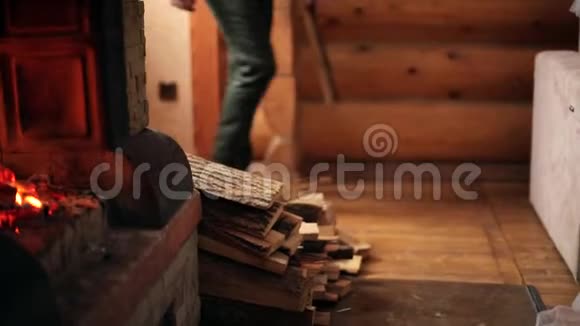 穿针织毛衣的年轻时尚男士在家里壁炉里扔木原木无法辨认的白种人男性视频的预览图