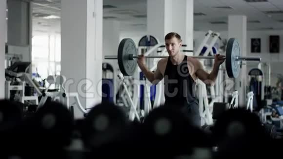 有魅力的强壮男子在健身房背起杠铃视频的预览图