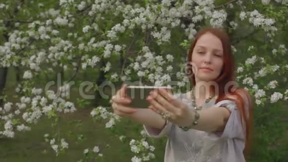 生活方式的女人在盛开的花园里打电话自拍视频的预览图