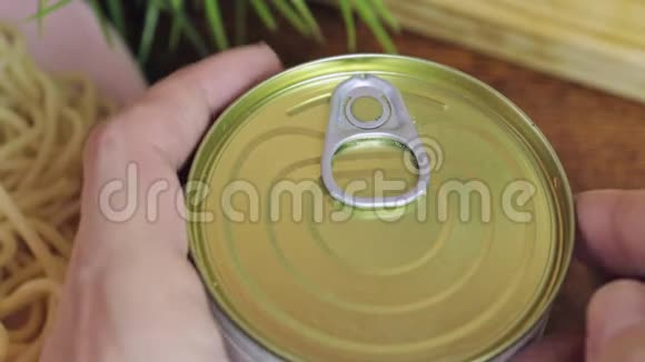 一只手打开罐头里的肉罐头用来做意大利面视频的预览图