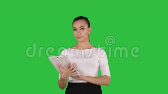在绿色屏幕上的平板电脑上有着严重的吸引力的年轻女性或学生阅读信息Chroma键视频的预览图