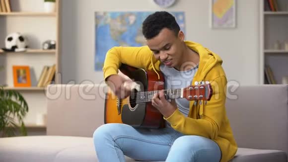 快乐的非裔美国青少年弹吉他享受最喜欢的爱好休闲视频的预览图