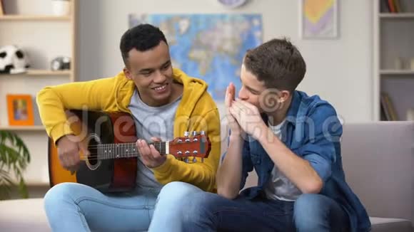 多种族青少年朋友弹吉他和口琴爱好音乐家的职业生涯视频的预览图