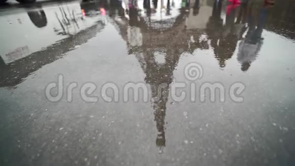 埃菲尔铁塔在一个水坑里经过的人的倒影巴黎在水下视频的预览图
