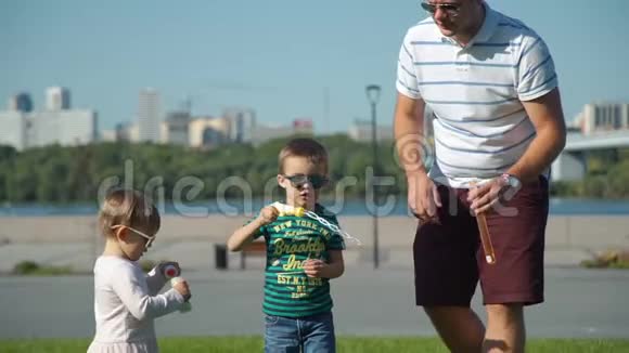 家庭在夏季公园吹肥皂泡视频的预览图