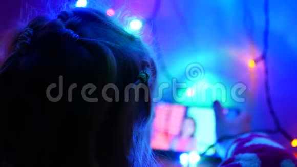 金发小女孩坐在地板上玩游戏节日房间的内部新年花环在地板上视频的预览图