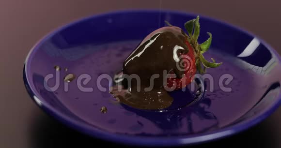 融化的黑巧克力中的果汁草莓撒上糖霜视频的预览图