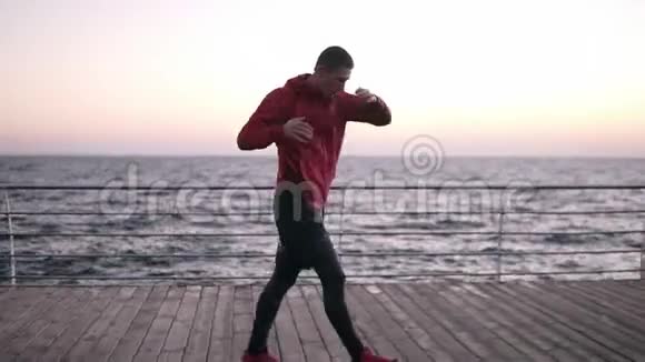 职业男拳击手户外训练站在战斗姿势努力工作使躯干转动关于视频的预览图
