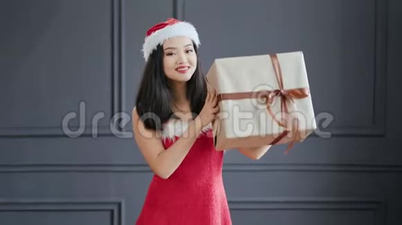 穿着圣诞老人套装的中镜头亚洲女性微笑着在演播室里捧场视频的预览图