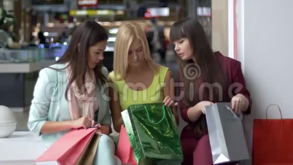 购物者的生活方式在黑色星期五的商场里女孩们拿着许多袋子谈论她们的购物日视频的预览图