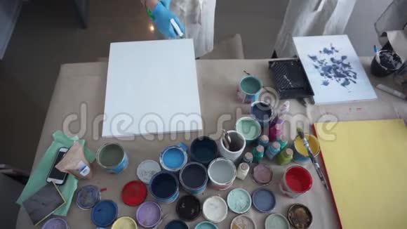 艺术家准备一幅画白色油漆穿围裙的人艺术工作室喷雾瓶视频的预览图
