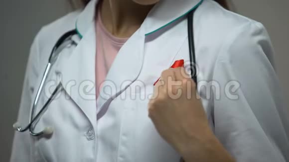 女医生在医疗服上贴上红丝带开展艾滋病宣传运动视频的预览图