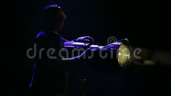 一个男性照明器从一个侧面聚光灯中描绘出一束光线并引导设备视频的预览图