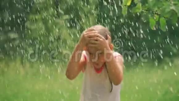 美丽的女孩在花园里泼水的肖像女孩完全湿透了这是非常炎热和快乐的一天概念视频的预览图