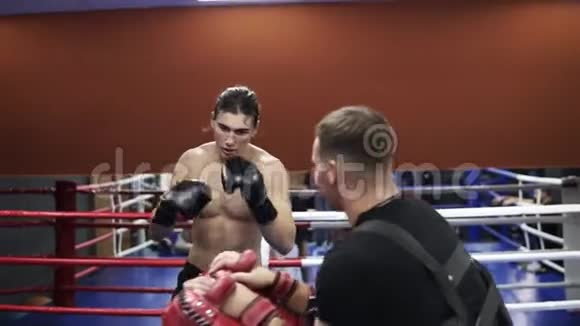 拳击手训练教练用拳爪使用拳击手套准备比赛汗脸赤膊视频的预览图