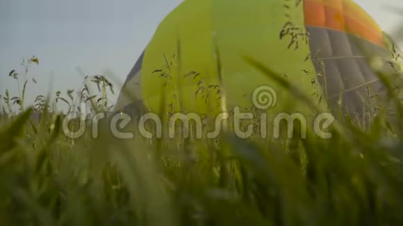 滑动摄像头充气热气球准备日出飞行早上雾蒙蒙的在草地上闪耀的露水视频的预览图