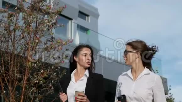 两个年轻的女商人走在街上聊天视频的预览图