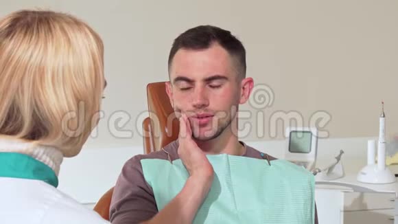 牙痛的男性病人在医院和牙医谈话视频的预览图