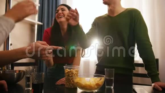 一群年轻朋友一起站在厨房里一个年轻的女人在笑视频的预览图