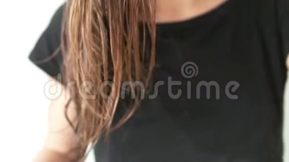 一个女人慢慢地梳理着湿漉漉的头发头发很大视频的预览图