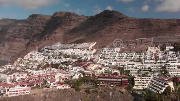 空中射击阳光明媚的一天在旅游山上的小镇上有许多酒店山路蜿蜒曲折视频的预览图