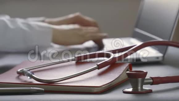 医生用鼠标在带有听诊器的笔记本电脑上工作视频的预览图