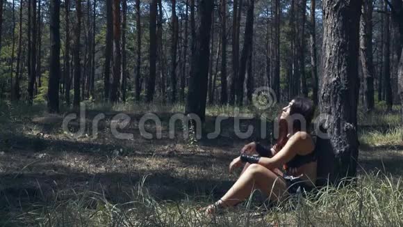 穿皮衣服的亚马逊女人正在森林里的一棵树下休息视频的预览图