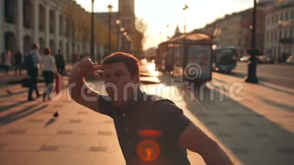 城市街道上迷人的年轻微笑男性舞蹈的随意肖像视频的预览图