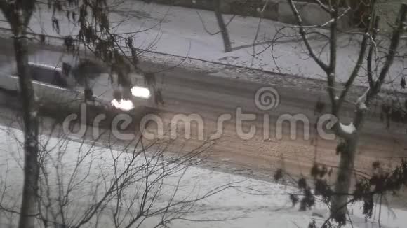 人们在冬天的雪夜在路灯柱下走在路边视频的预览图
