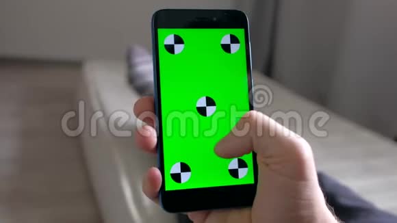 手动输入智能手机与绿色屏幕躺在床垫在房间视频的预览图