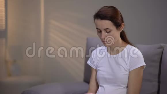 哭泣的孕妇抱着粉红色袜子先天性异常妊娠丢失视频的预览图