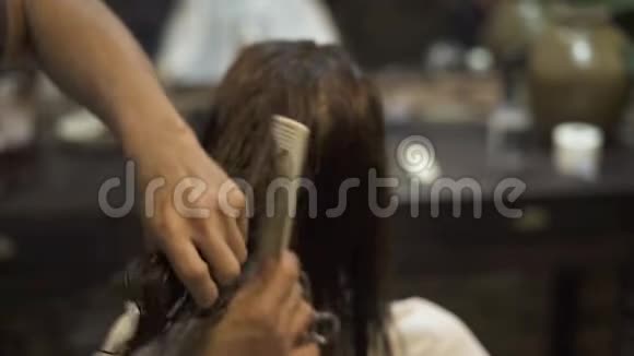 美发师在美容工作室用理发剪梳理湿发发型师用剪刀和梳子视频的预览图