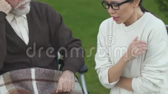 女儿在坐轮椅的老父亲身边哭泣因患癌症而沮丧视频的预览图