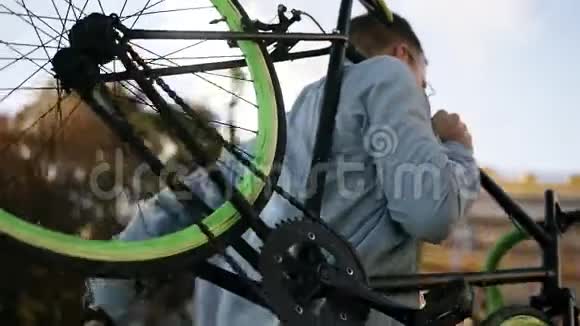 一个穿着便装戴着墨镜英俊的白种人年轻男子正在上楼的时候他正肩搭着一辆自行车视频的预览图