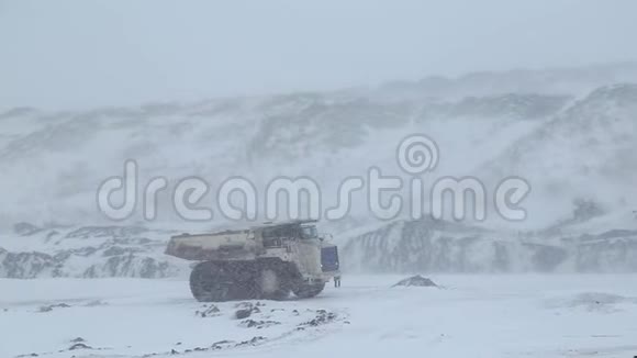 冬天一辆翻斗车驶过露天煤矿视频的预览图