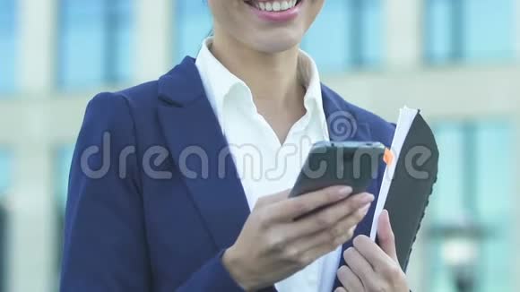 亚洲女商人从智能手机上读到好消息很高兴升职视频的预览图