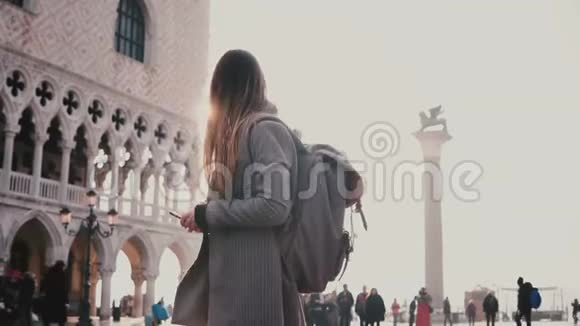 快乐的女游客用智能手机拍摄意大利威尼斯圣马可广场SanMarcosquare的迷人照片视频的预览图