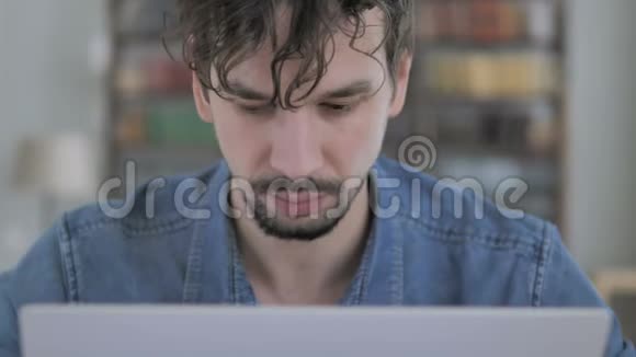 损失关闭紧张青年在笔记本电脑上工作视频的预览图