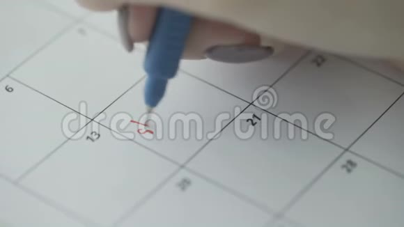 女人用红笔在日历上写字购物视频的预览图