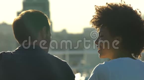 非洲裔美国妇女和高加索男友在户外约会时交谈后视视频的预览图