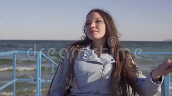 轮椅上的残疾青年妇女在斜坡上靠海休息视频的预览图