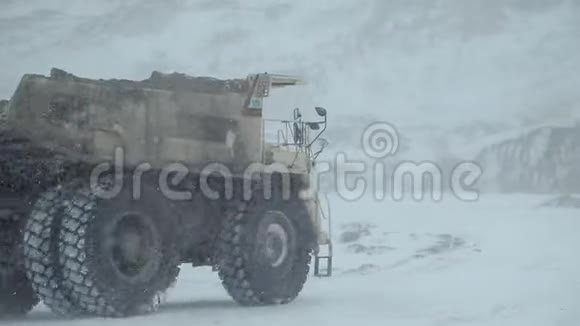 冬天一辆翻斗车驶过露天煤矿视频的预览图