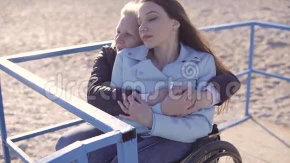 轮椅上的残疾青年妇女在坡道上的海边玩得开心视频的预览图
