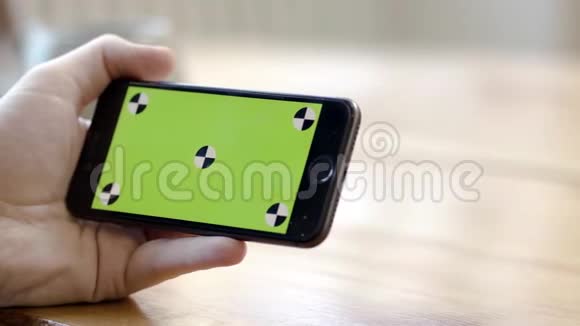 用绿色屏幕水平特写手持手机库存录像一人水平手持电话视频的预览图