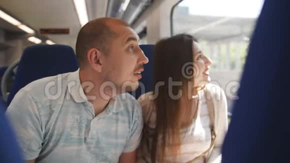 一对相爱的夫妇坐在elektro火车上透过窗户看着周围的环境视频的预览图