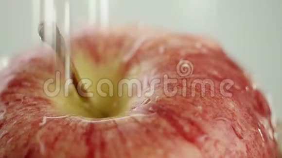 在视频中我们看到一个红色的苹果水从顶部像水滴一样倾泻白色的背景特写视频的预览图